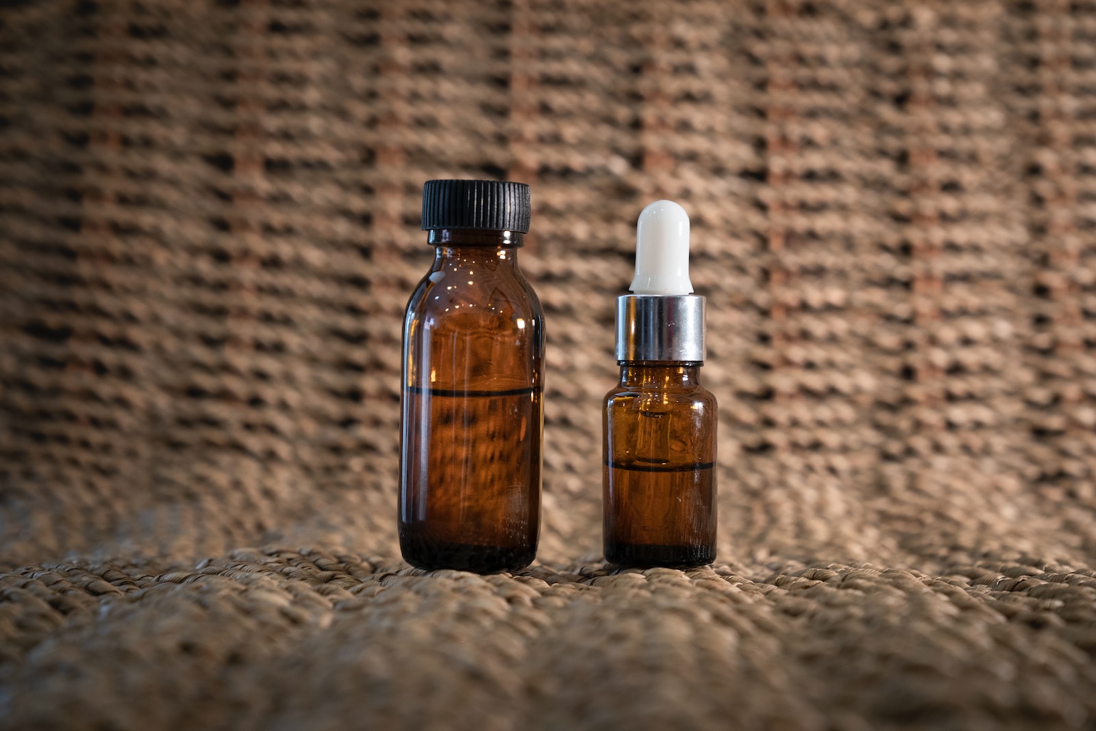 two bottles of essential oils sitting on a cloth